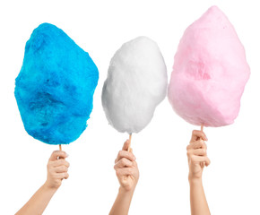 Female hands with different cotton candy on white background