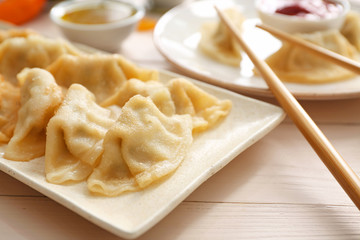 Plate with tasty Japanese gyoza on table, closeup