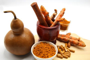 fresh root organic turmeric with powder and capsule on white background