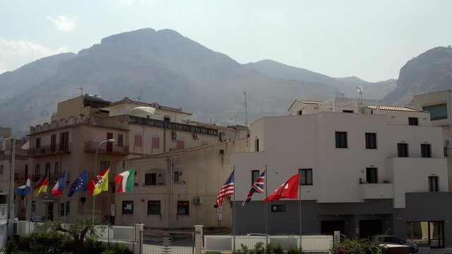 Flags of different countries at the building on a Sunny day. Action. Flags of the world on the streets of the southern city
