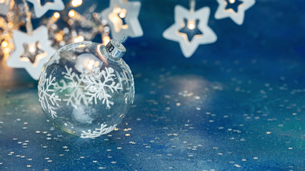 festive new year background with christmas tree glass ball and glowing star garlands blurred...