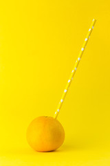 orange with yellow paper straw isolated  on a orange colored background 