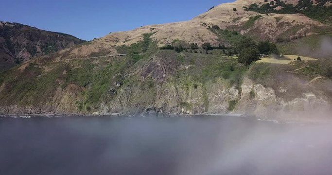 Flying above clouds over Big Sur Pacific Coast, aerial reveal