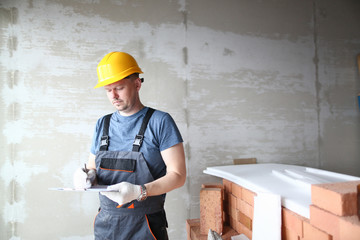 Male builder in yellow hard hat holds