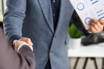 young happy businessmen have meeting in office shake hands with each other closeup