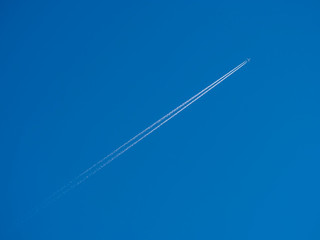 Commercial plane fliying on the blue sky diagonally in to the frame