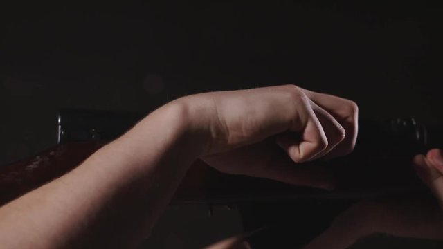 Hands reloading an SKS Russian rifle and aiming the target in slow motion, Close up, black background, indoor.