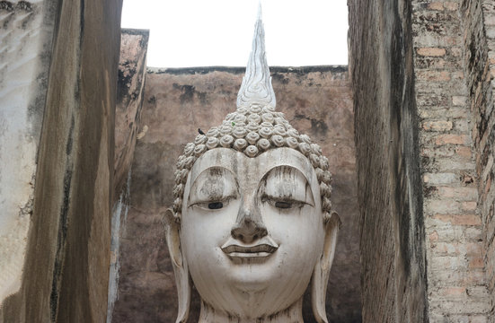 The ancient Phra Ajana Buddha image statue at Srichum temple in the old historical park in Sukhothai province , Thailand.