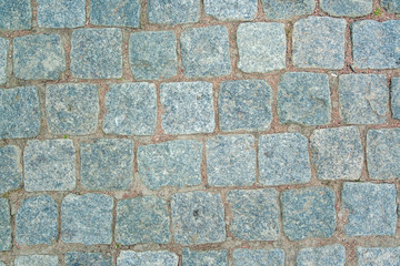 Old aged granite paving stones. Texture of old granite paving stones. The texture of the pavement granite pattern wallpaper for design. Rough texture.