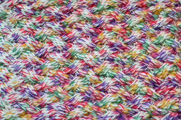 Knitted carpet closeup. Knitted texture. Detailed warm yarn background. Knit wool. Natural woolen fabric, sweater fragment.