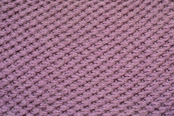Knitted carpet closeup. Knitted texture. Detailed warm yarn background. Knit wool. Natural woolen fabric, sweater fragment.