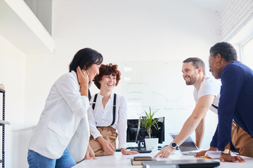 Young team of international people take rest after discussing business ideas in office, smile laugh together, happy