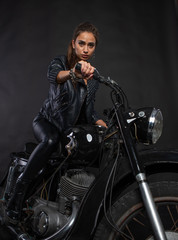Naklejka na ściany i meble girl on a motorcycle in black clothes