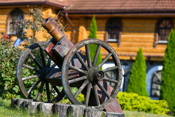 Fototapeta na wymiar old iron gun. A cannon that shoots cores. Burning wick. Current model of an old artillery gun. naked gun, cannon on wheels, american civil war