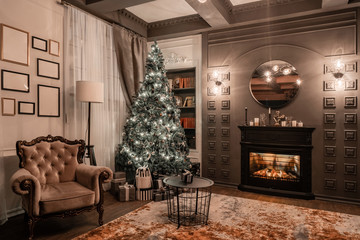 Christmas evening by candlelight. classic apartments with a fireplace, decorated tree, sofa, large...