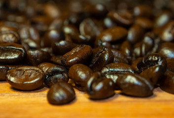 Coffee mugs and coffee beans resting on a brown wooden table.