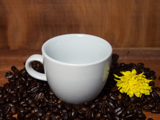 Coffee mugs and coffee beans resting on a brown wooden table.