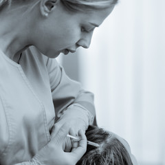 Woman with hair loss problem doing injection for hair growth, black and white image with blue tinted