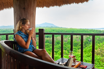 Happy family travel, explore rainforest near Pemuteran. Young woman drink morning coffee and relax...