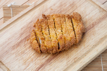 Japanese food, deep fried porkchop Tonkatsu on chopping wood.