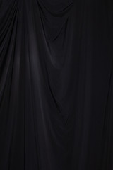 Black Curtain drape wave with studio lighting, Wallpaper Background Texture Detail of light and...