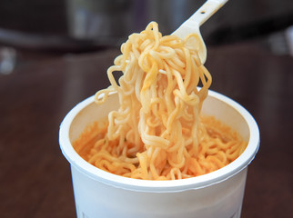 Fastfood spice instant noodles. Cooked instant noodles soup in the white plastic cup.