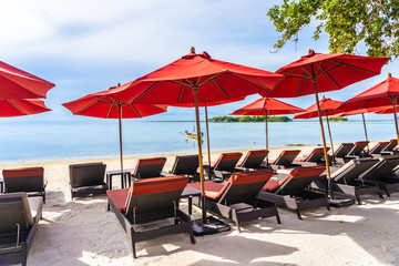 Beautiful outdoor tropical beach sea ocean with umbrella chair and lounge deck around there on white cloud blue sky
