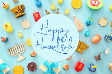 religion image of jewish holiday Hanukkah background with menorah (traditional candelabra), spinning top over wooden blue background. top view, flat lay