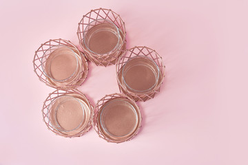 round composition of candlesticks in rose gold on a pink background. top view, copy space