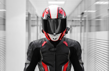 A man in a helmet and full motorcycle gear. In offices - obrazy, fototapety, plakaty