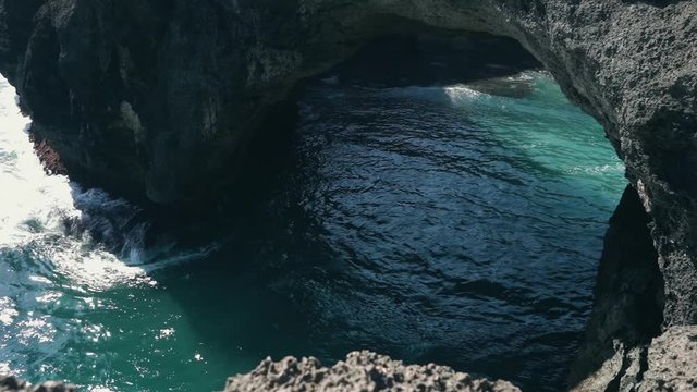 Ocean view to the Devill eye coast formation with blue lazure ocean water. Bali Indonesia