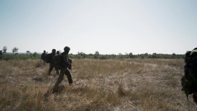 Soldiers walking across a field