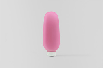 Transparent plastic tube with pink gel isolated on soft gray background