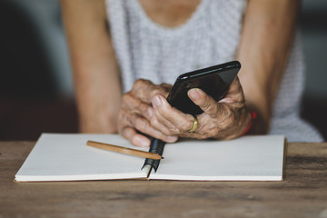 Old woman holding smart phone for shpping online