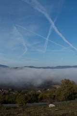 Contrails over a fog filled valley
