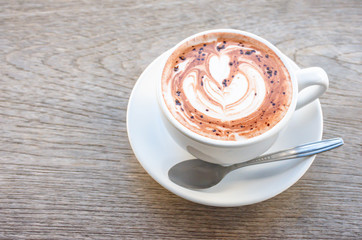Top view hot coffee Espresso topped with a heart shaped milk in white glass on wooden table.