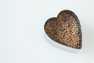 Cooking grits lentils in a metal heart-shaped