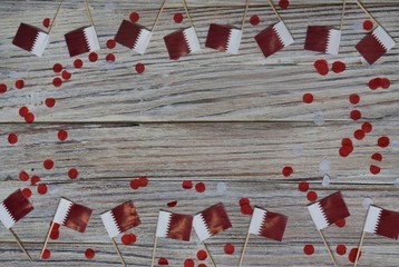 December 18 . independence day of Qatar. mini flags on wooden background with paper confetti. happy day of patriotism, freedom and memory