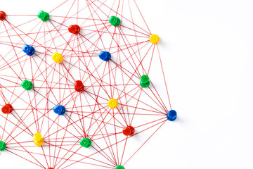 Network with colorful pins and string,  linked together with string on a white background suggesting a network of connections.