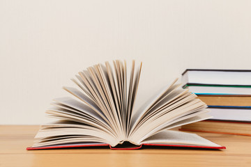 Simple composition of many hardback books, raw of books on wooden table and light  background