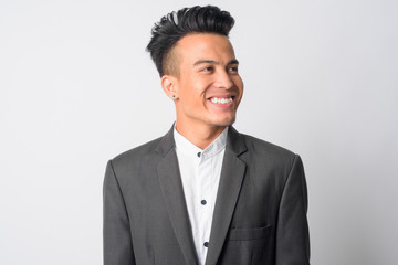 Face of happy young Asian businessman in suit thinking
