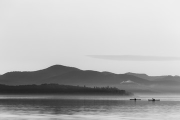 Beautiful view of a lake with two distant men on canoes