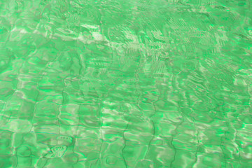 Water surface in a swimming pool. Green color abstract background 