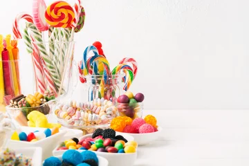 Fotobehang Different colorful candy sweets. Mix candy confectionery in jars on white wooden background with copy space © karlevana