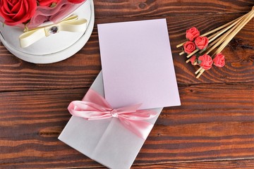 Gift box with flowers on wooden background, preparation for the holiday concept. Top view and copy area for text.
