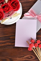 Gift box with flowers on wooden background, preparation for the holiday concept. Top view and copy area for text.