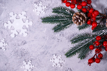 Obraz na płótnie Canvas Christmas or winter composition. Gray background with white snowflakes and fir branches. Flat lay, top view, space for text.