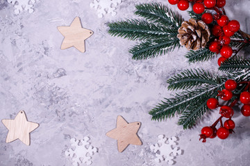 Christmas or winter composition. Gray background with white snowflakes and fir branches. Flat lay, top view, space for text.