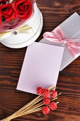 Gift box with flowers on wooden background, preparation for the holiday concept. Top view and copy area for text.