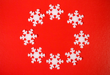 Christmas or winter frame. Snowflakes in the shape of a circle on a red background. Flat lay, top view, space for text.